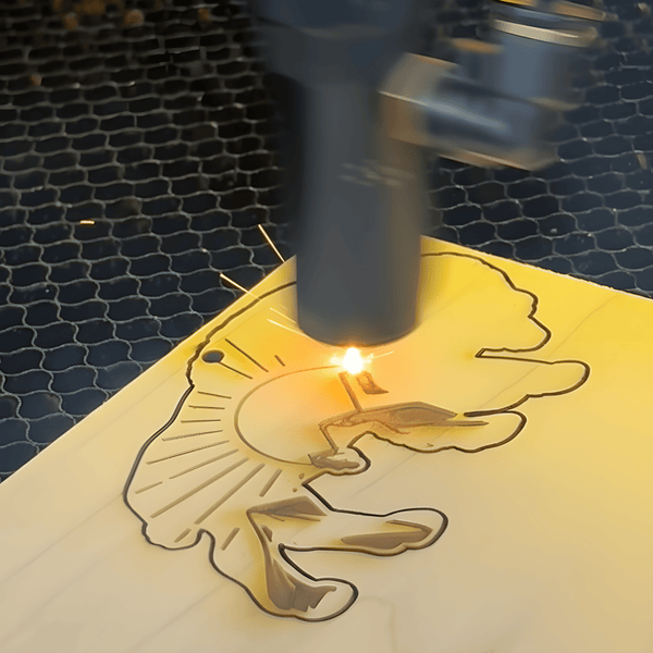 Laser engraving process on a wooden board with a design.